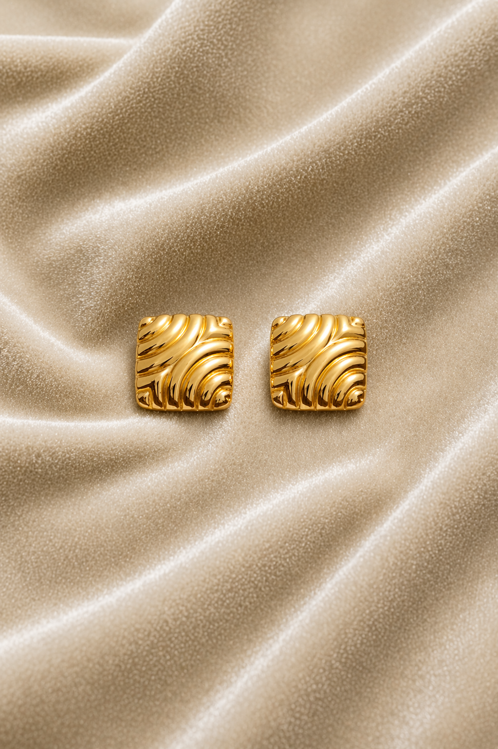 Square gold stud earrings on velvet