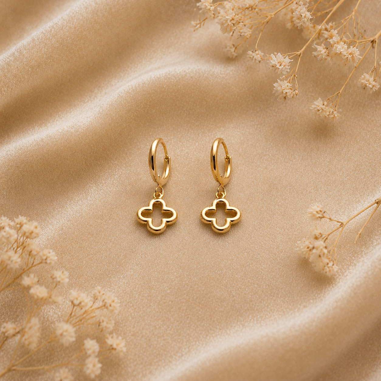 sleek clover drop gold hoop earrings on satin