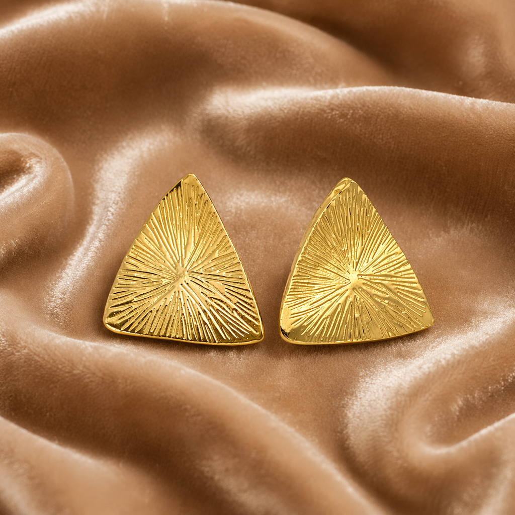 Bold gold stud earrings on velvet