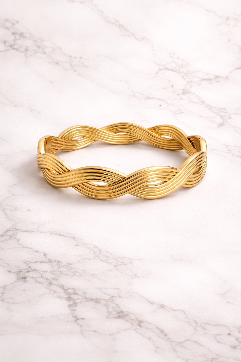 Wave design gold cuff bracelet on marble