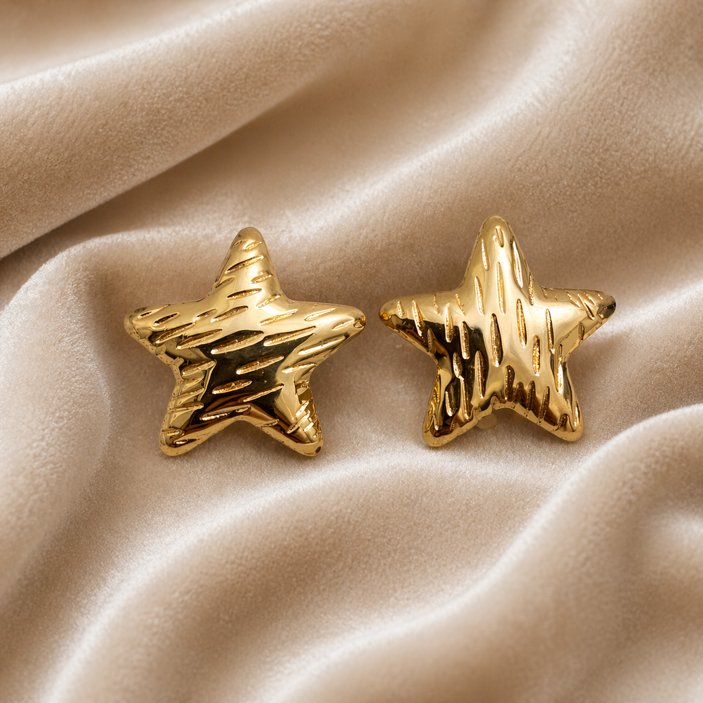Textured gold star stud earrings on velvet
