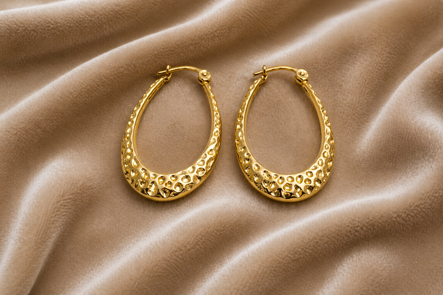 Textured gold hoop earrings on velvet
