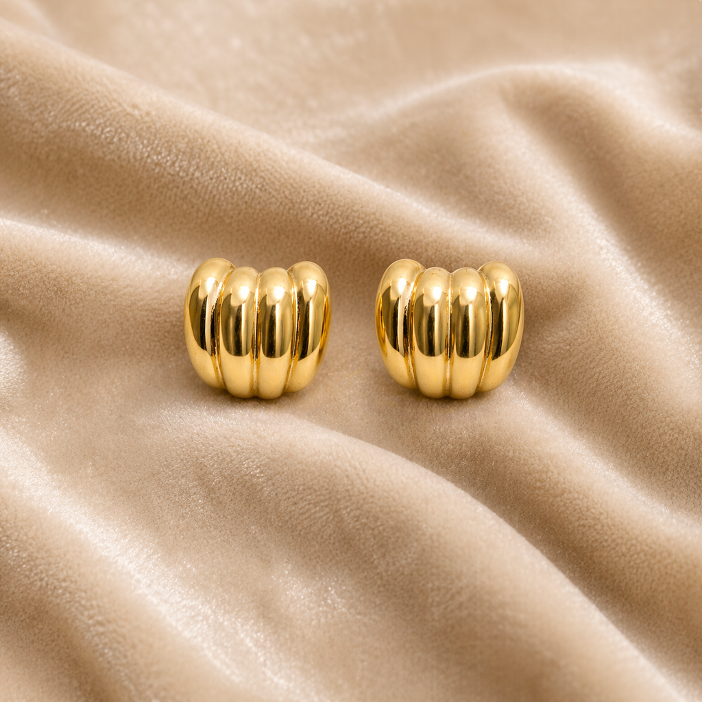 Gold ribbed stud earrings on velvet