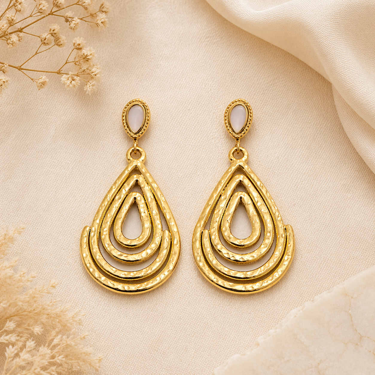 Gold drop earrings on satin
