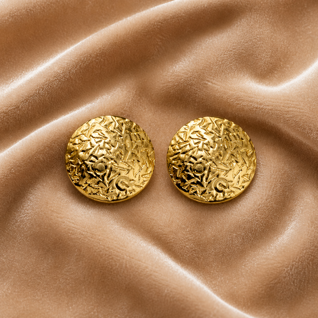 Classic round gold stud earrings on velvet
