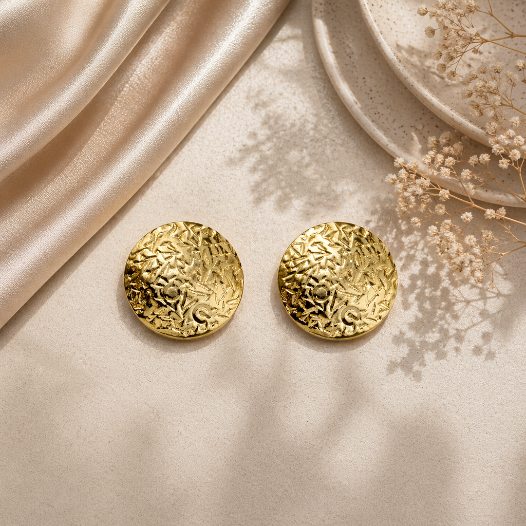 Classic round gold stud earrings on marble
