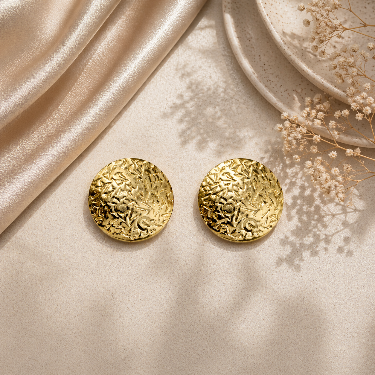 Classic round gold stud earrings on marble
