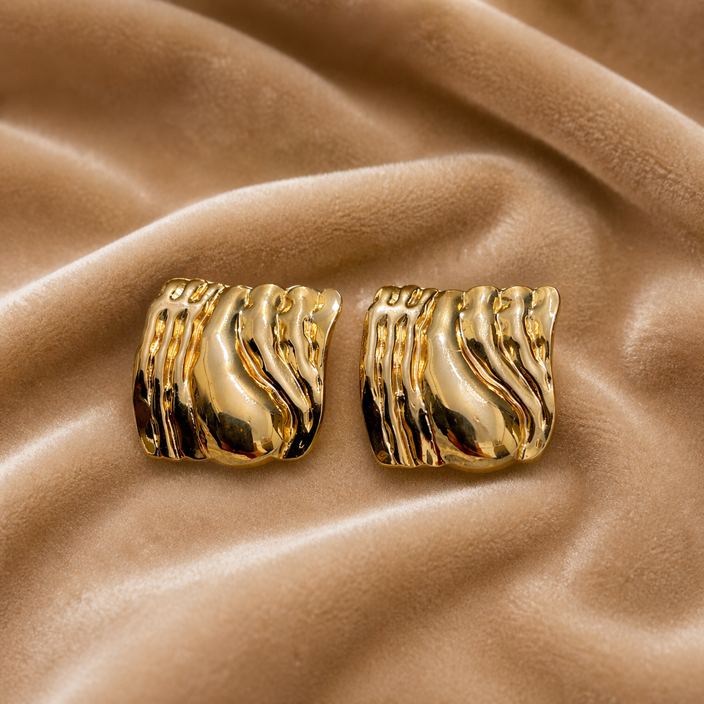 Sculpted molten stud earrings on velvet