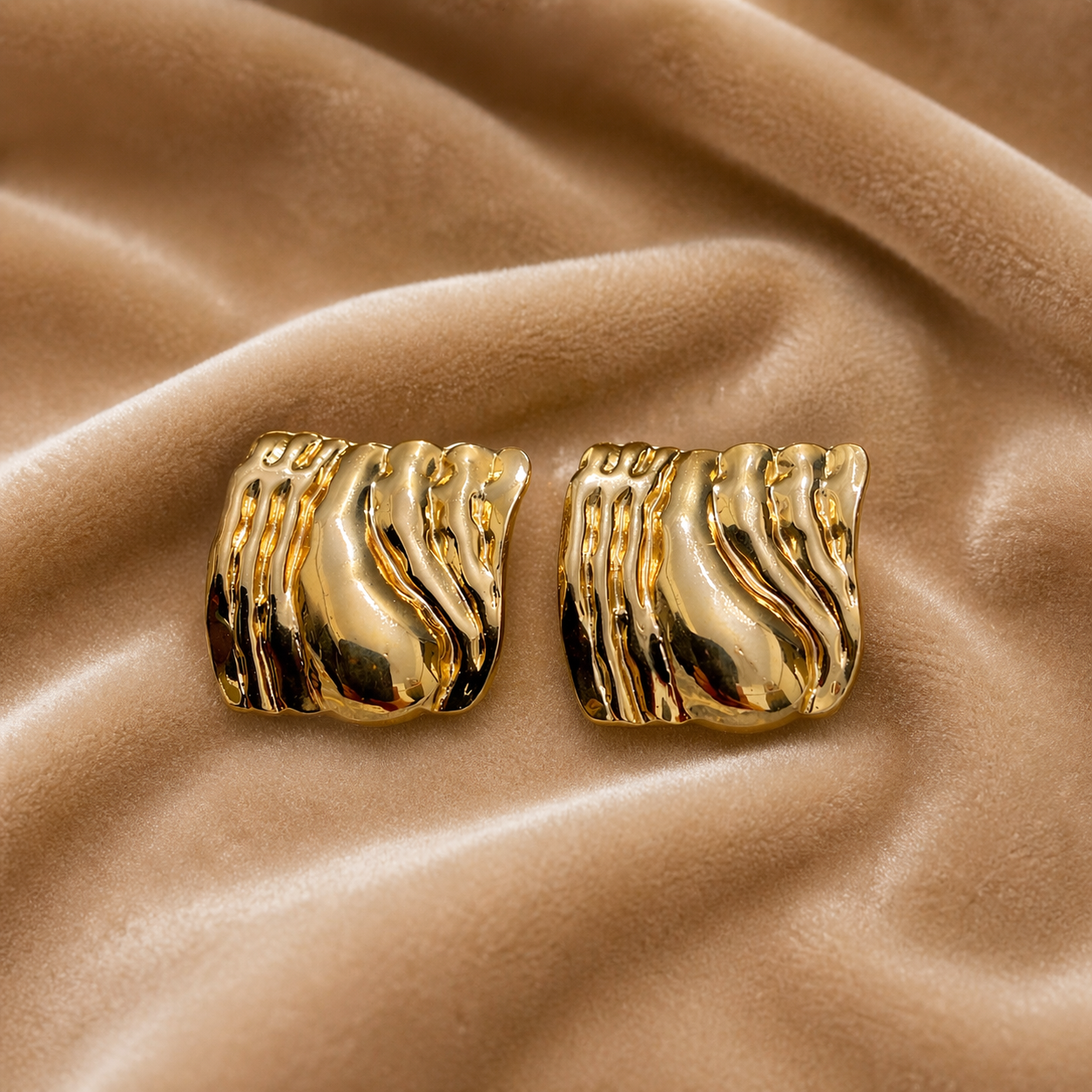 Sculpted molten stud earrings on velvet