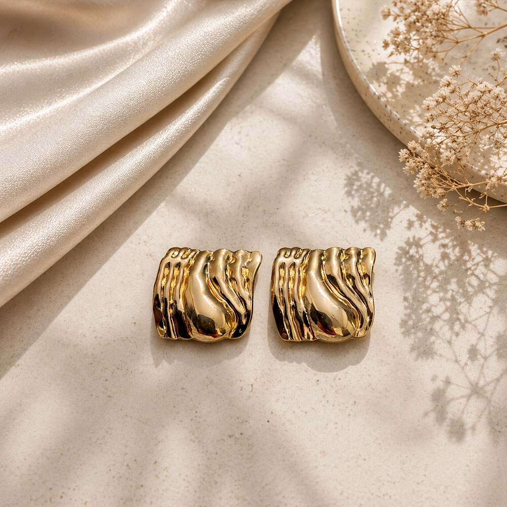 Sculpted molten stud earrings on marble 