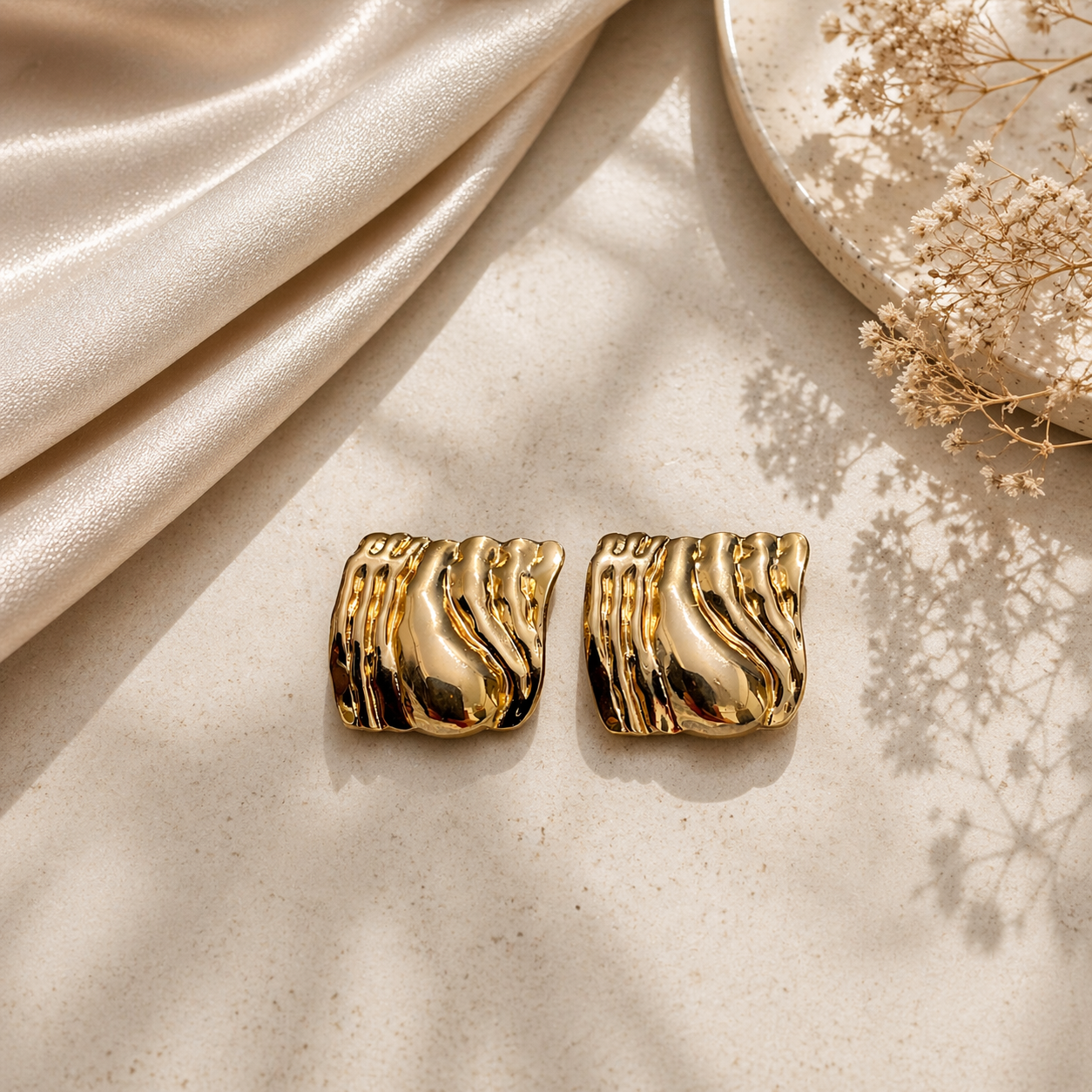 Sculpted molten stud earrings on marble 