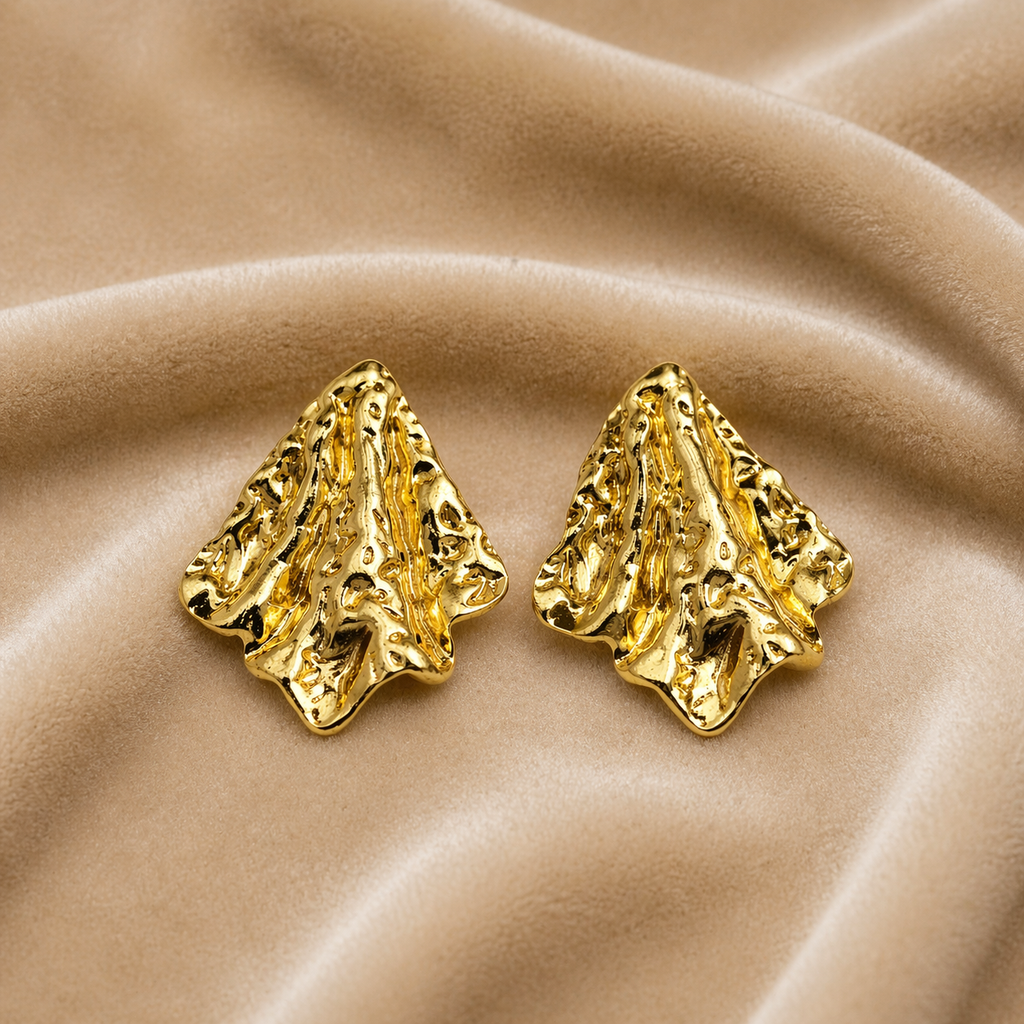 Elegant gold textured stud earrings on velvet