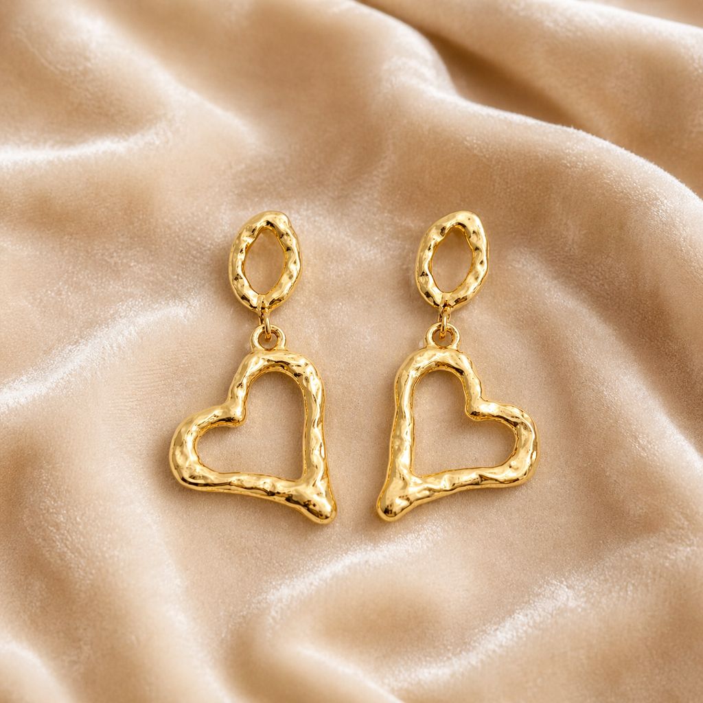 Gold heart drop earrings on velvet