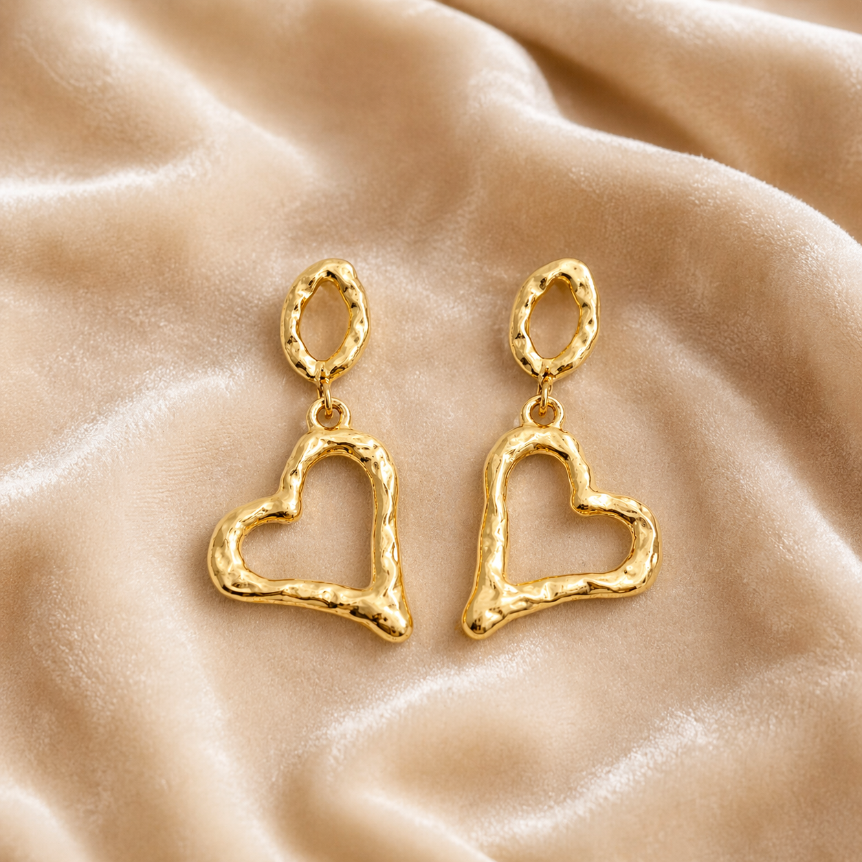 Gold heart drop earrings on velvet