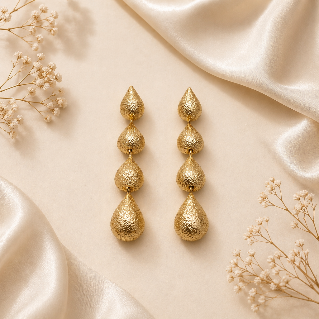 Layered gold drop earrings on marble