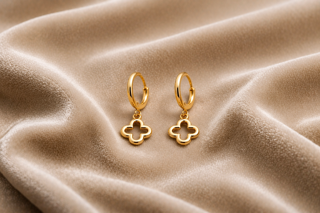 sleek clover drop gold hoop earrings on velvet