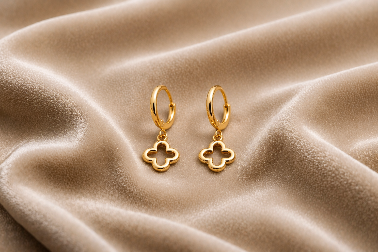 sleek clover drop gold hoop earrings on velvet