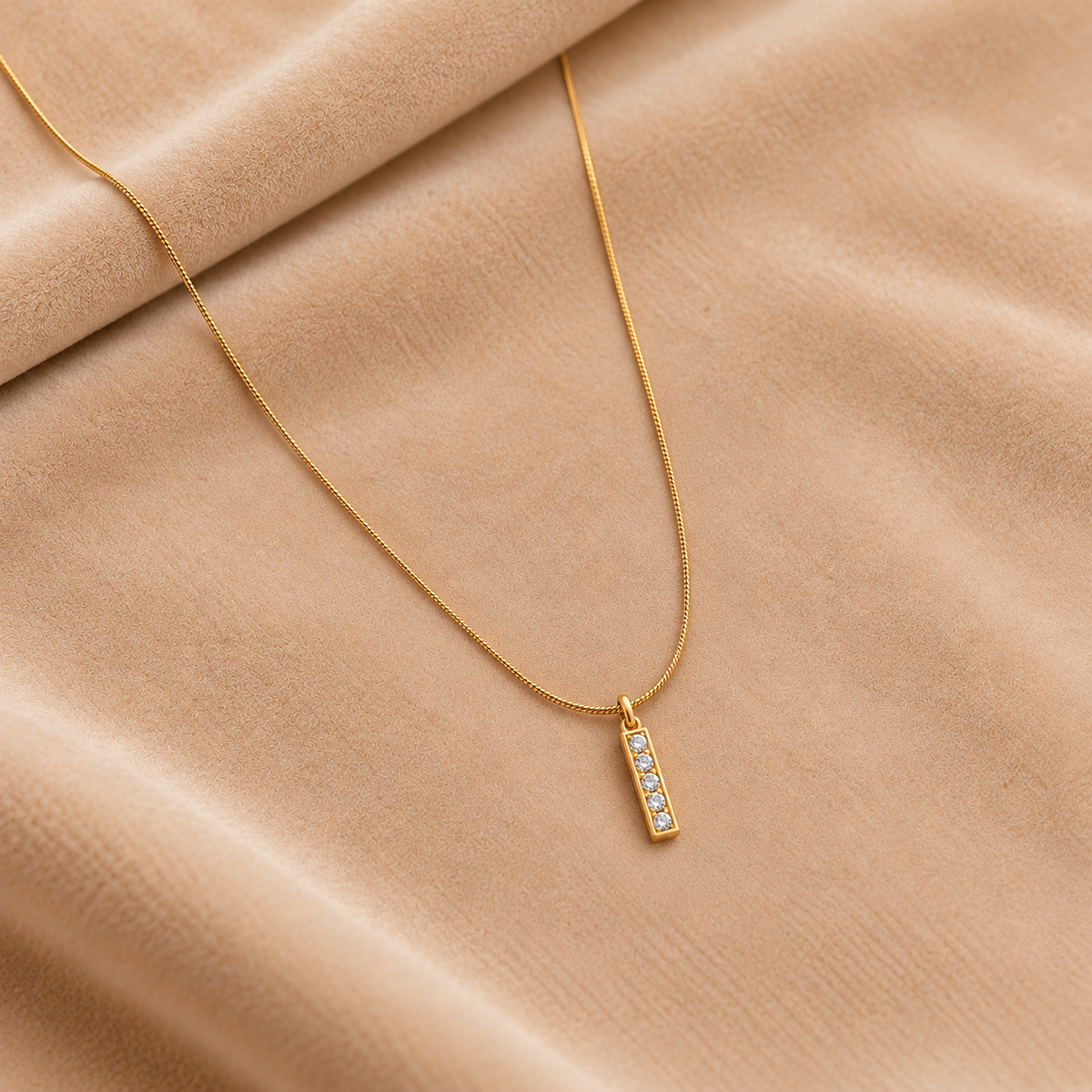 Gold Bar Pendant Necklace with Crystal Accents on velvet