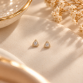 Gold Triangle Halo Stud Earrings on flat lay