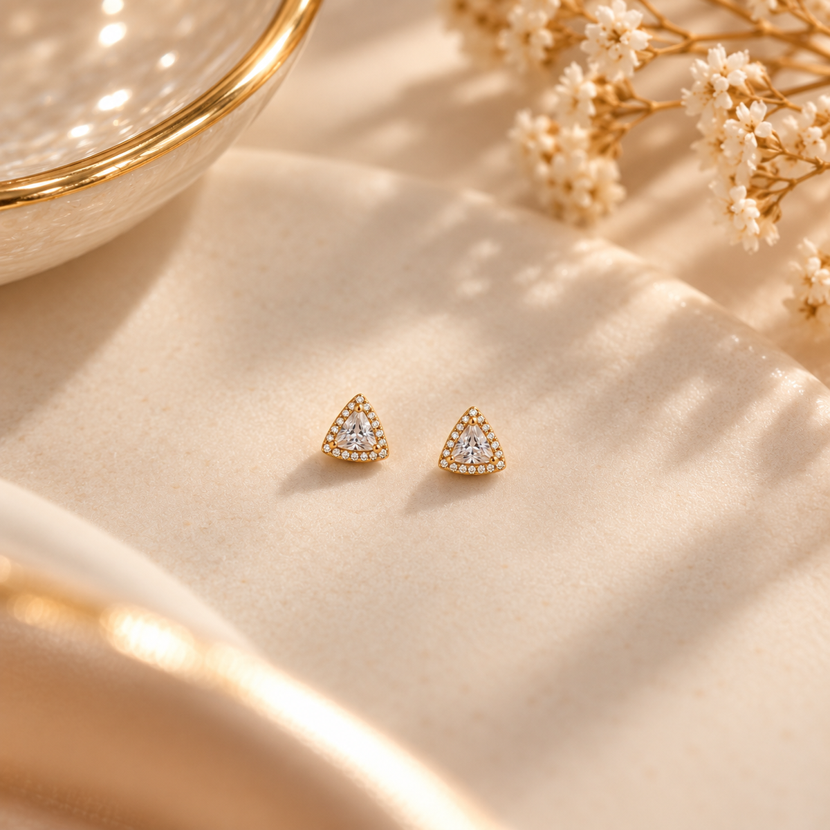 Gold Triangle Halo Stud Earrings on flat lay