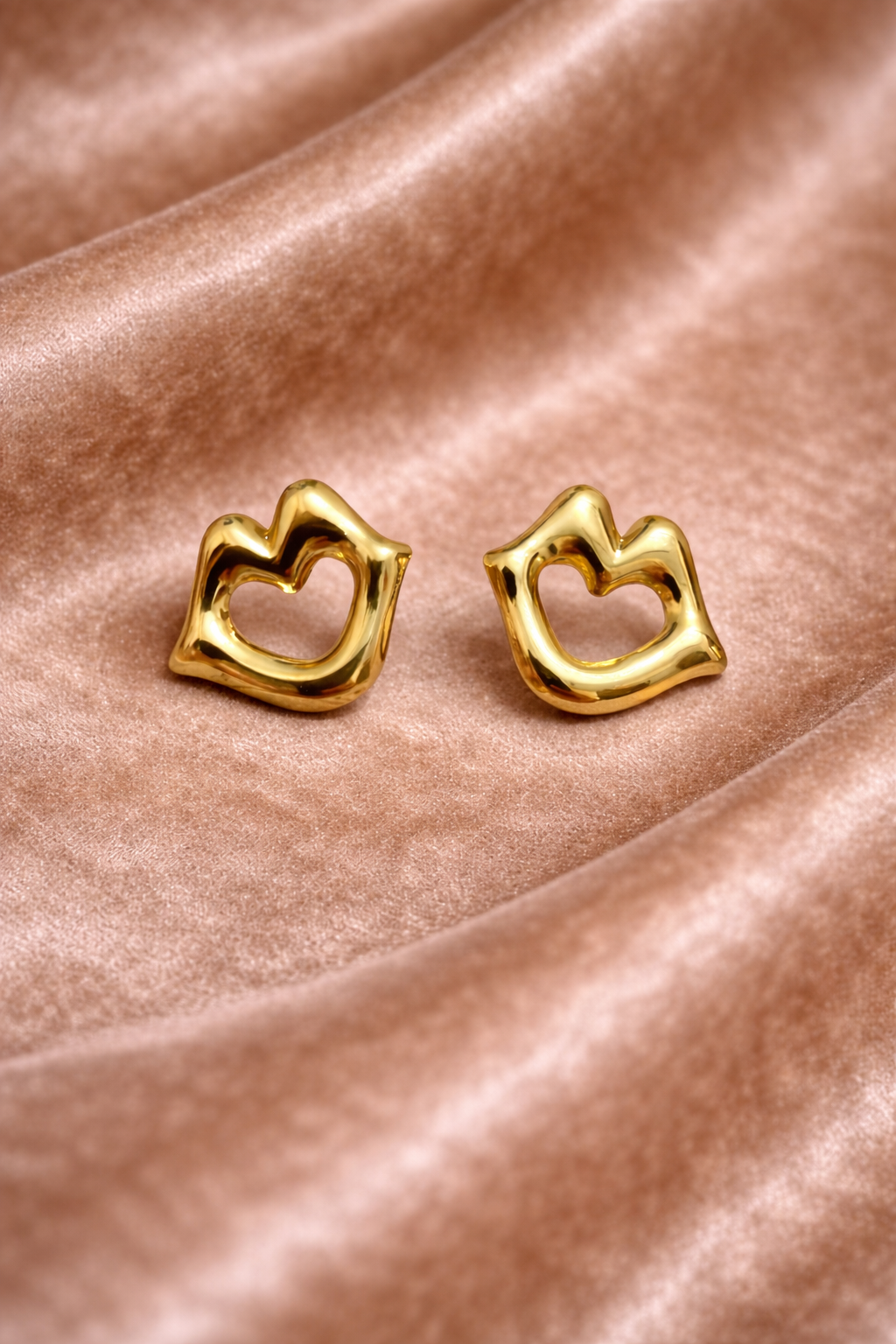 Elegant gold laugh shape earrings on velvet