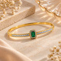 Emerald Green Crystal Gold-Tone Bangle Bracelet on flat lay