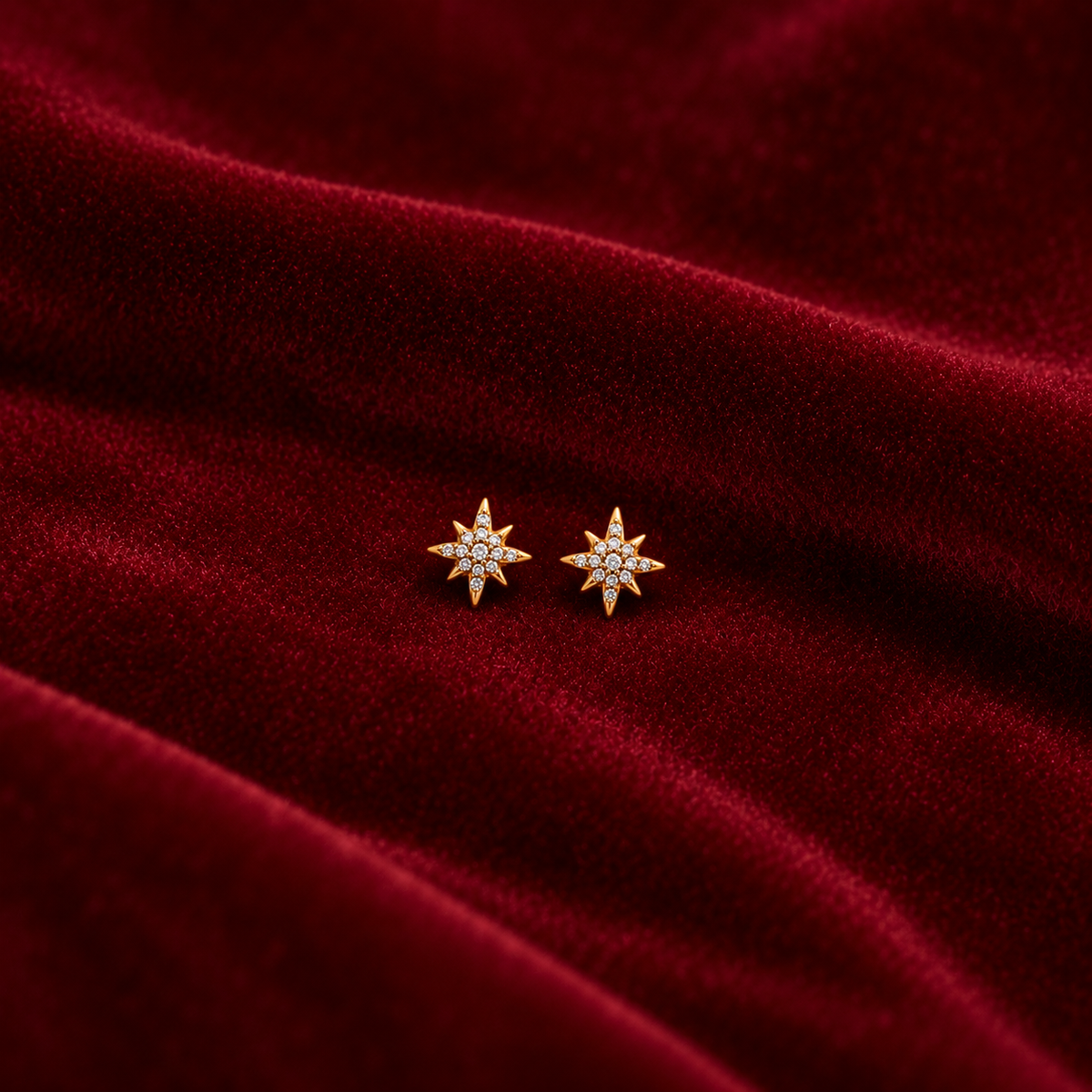 Gold Starburst Stud Earrings on velvet