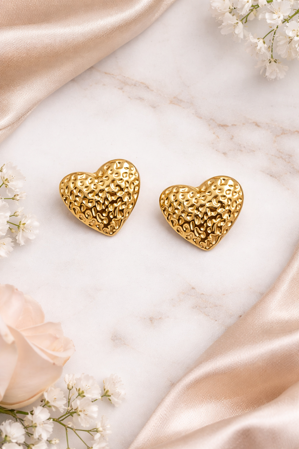 gold heart earrings on flat surface