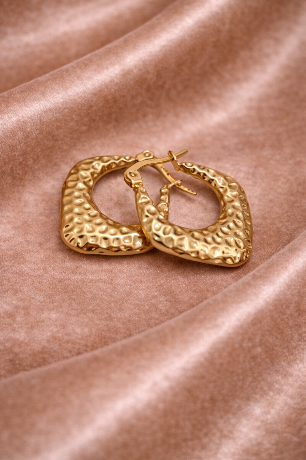 Elegant gold hoop earrings on velvet